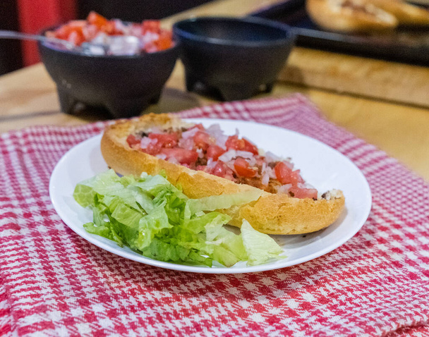 Mexický salát a salát na talíři nad bílým a červeným kostkovaným ubrouskem - Fotografie, Obrázek