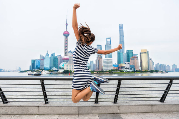 Happy woman jumping of success in city - 写真・画像