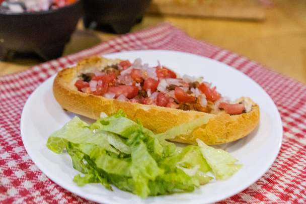 Мексиканский моллет и салат на тарелке над белой и красной клетчатой салфеткой - Фото, изображение