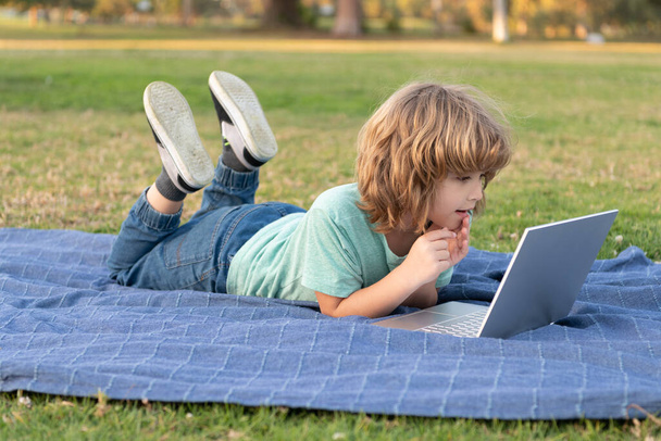 печатать школьный блог на компьютере. Маленький мальчик на видео уроке. мальчик-подросток использует ноутбук. - Фото, изображение