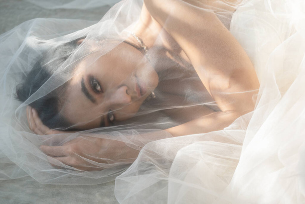 dramatic art portrait of beautiful asian female model in white wedding dress - Фото, зображення