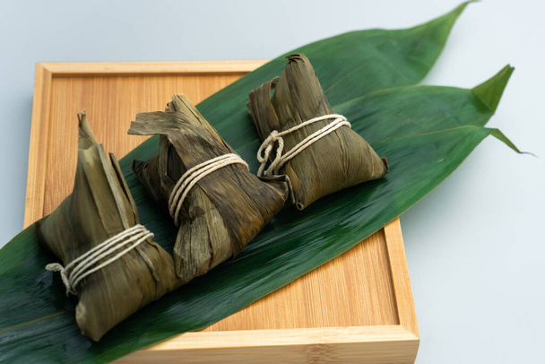 Tři zongzi na bambusovém tácu. Tři rýžové knedlíky na bambusovém tácu. - Fotografie, Obrázek