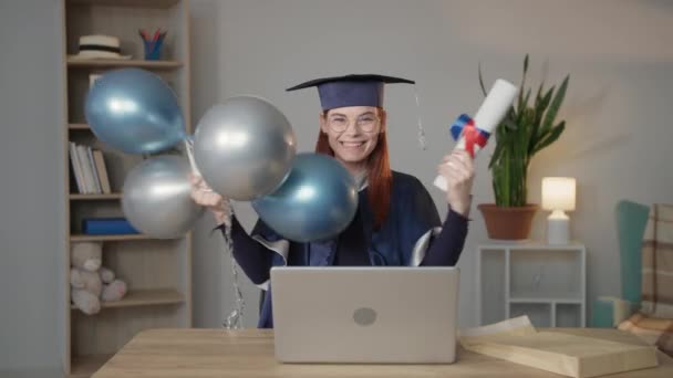 modern learning, happy female student in mantle and hat rejoices at university diploma with balloons in hands - Footage, Video