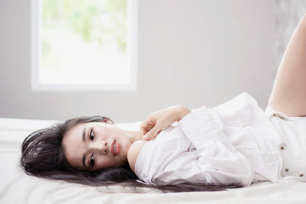 Gyönyörű ázsiai nő pár alszik az ágyban. Reggeli álom. Vonzó lány pihen egy kényelmes ágyban egy párnán.. - Fotó, kép