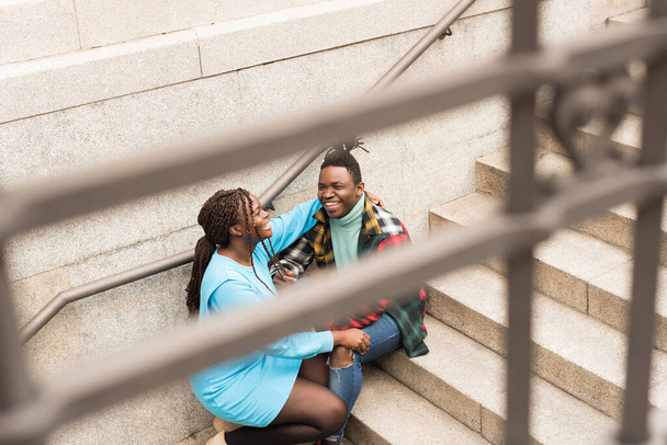 Black couple sitting on a stairs in the city. - Foto, Bild