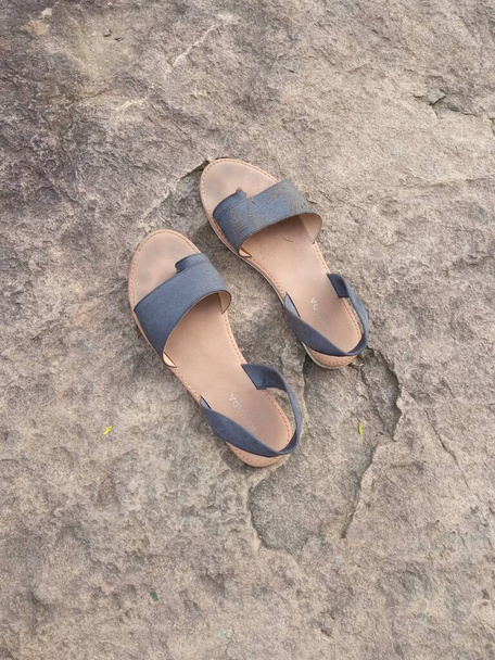 Um par de sandálias molhadas numa grande rocha - Foto, Imagem