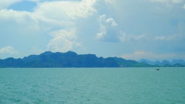Panorámás kilátás egy turisztikai közlekedési hajó felé Ázsia egyik szigetén a nyaralás, amely gyönyörű táj át a zöld hegyek. Hozd a tengert, a kék eget és a fehér felhőket.. - Felvétel, videó