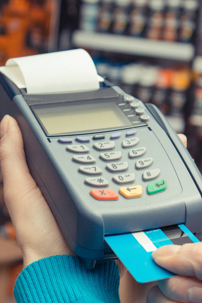 Payment terminal with credit card as device using for cashless paying for shopping in shop. Finance and banking concept - Photo, image