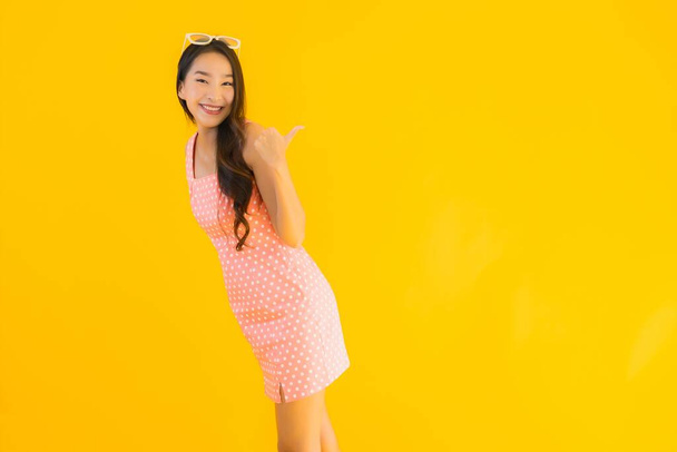 Portré gyönyörű fiatal ázsiai nő mosoly boldog sárga elszigetelt háttér - Fotó, kép