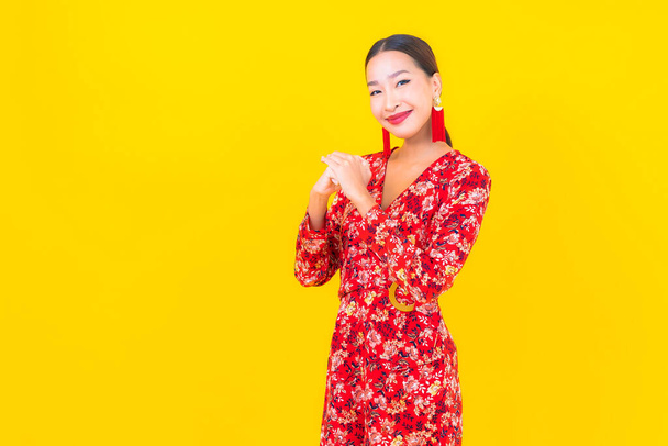 肖像画の美しい若いアジアの女性の笑顔アクションで中国の新年の概念上の色の背景 - 写真・画像