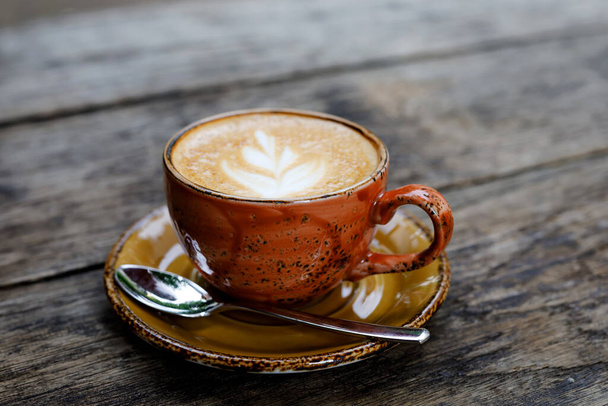 Чашка плоского белого кофе на деревянном столе в открытом кафе или ресторане. Сельский стиль. - Фото, изображение