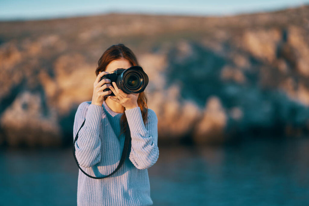 portret van een vrouwelijke fotograaf met een professionele camera buiten in de bergen. Hoge kwaliteit foto - Foto, afbeelding