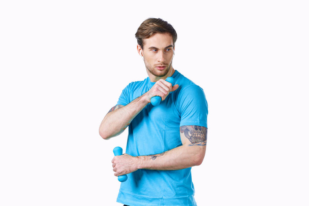 スポーティな男で青tシャツからダンベルで手フィットネスクロップドビュー - 写真・画像