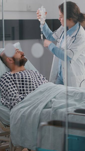 患者のバイタルチェック心拍数を監視する医療チームが流体を支援 - 写真・画像