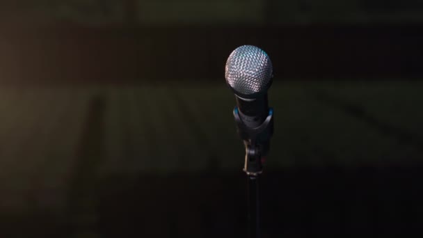 Mikrofon für Zeremonie und Konferenz steht auf Standhintergrund der Halle und Lichtstrahlen vom Scheinwerfer - Filmmaterial, Video