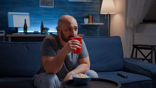 Człowiek korzystających z czasu oglądania serialu telewizyjnego w domu siedzi na wygodnej kanapie - Zdjęcie, obraz