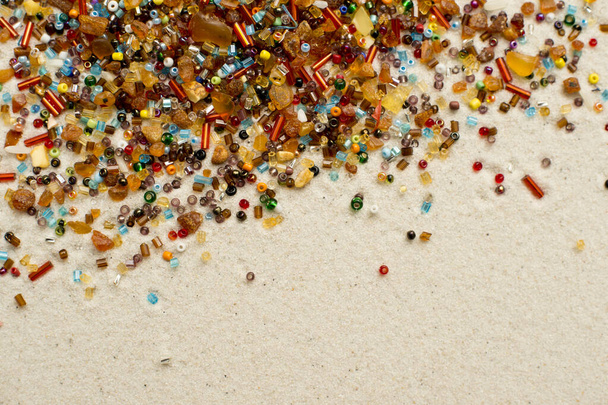Stars falling. amber and beads on white sand background. - Photo, Image
