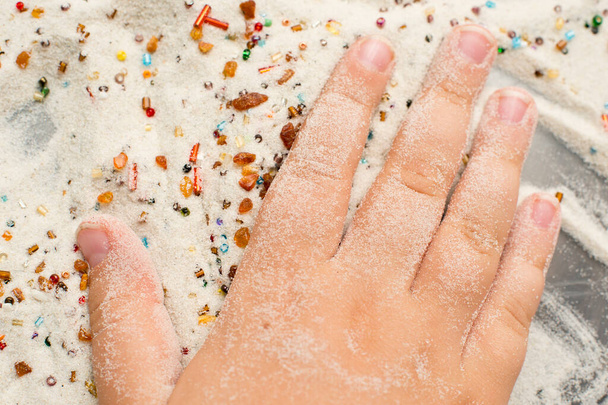dětské ruce na písku. úžasné složení perlí, křemene a přírodního jantaru. - Fotografie, Obrázek