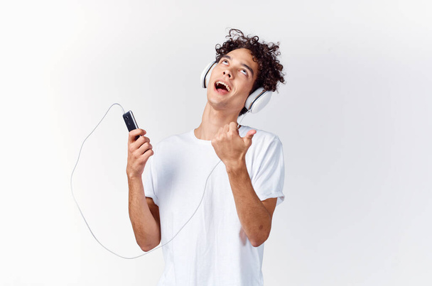 érzelmes férfi fehér pólóban zenét hallgat fejhallgatóval kivágott kilátással. Kiváló minőségű fénykép - Fotó, kép
