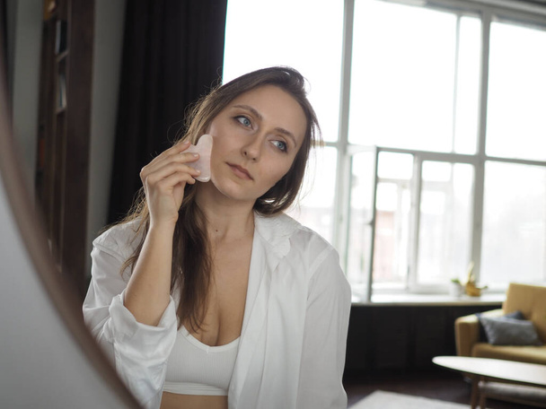 jovem fazendo rosto, massagem corporal, massagem anti-celulite com uma escova seca - Foto, Imagem