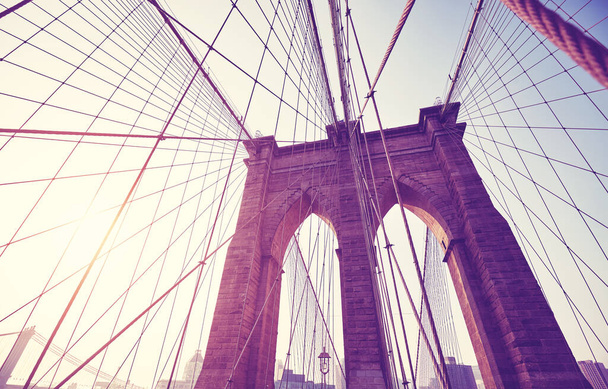 Retro tónovaný obrázek Brooklynského mostu proti slunci, New York City, USA. - Fotografie, Obrázek