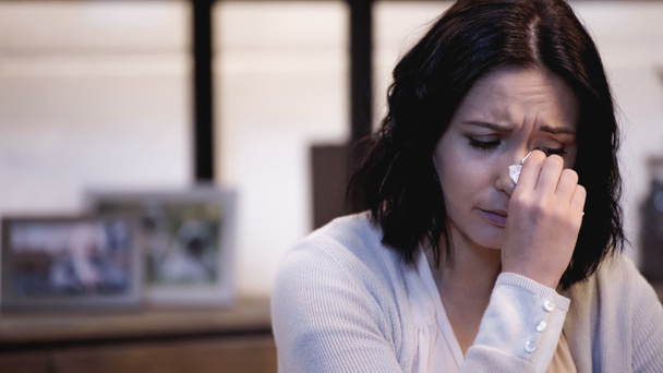 депрессивная женщина вытирает слезы бумажной салфеткой дома - Фото, изображение