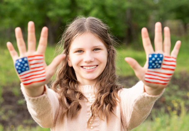 Aranyos kislány festett kezekkel, amerikai zászló színben. Az USA július 4-ét ünnepli. Függetlenség napja  - Fotó, kép