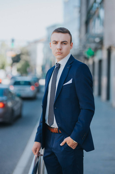 A caucasian young businessman in suit and tie standing outdoor - Fotó, kép