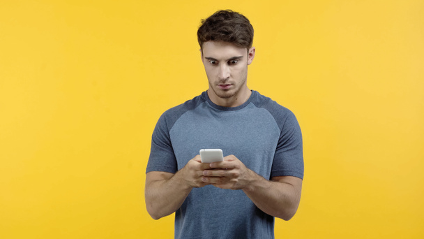 Izgalmas férfi használ okostelefon elszigetelt sárga  - Fotó, kép