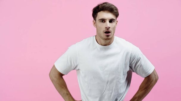 Shocked man in white shirt standing isolated on pink - Foto, immagini