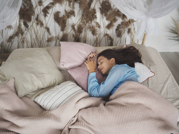 Fiatal nő alszik az ágyon otthon - Fotó, kép
