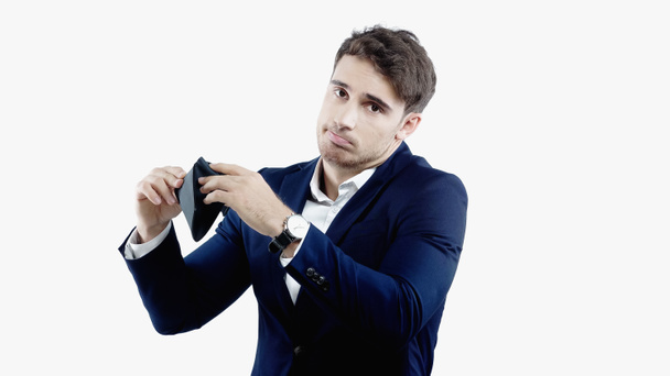 Confused businessman looking at camera while holding empty wallet isolated on white - 写真・画像