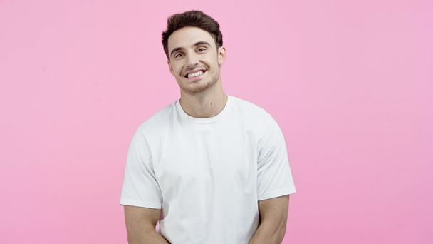 Good looking man in white t-shirt looking at camera isolated on pink - Fotografie, Obrázek
