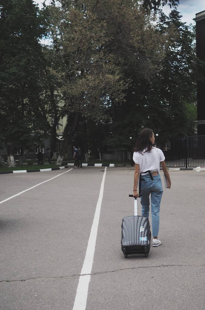 молода жінка з багажем їде у відпустку. їхати, хіміолан на колесах
 - Фото, зображення