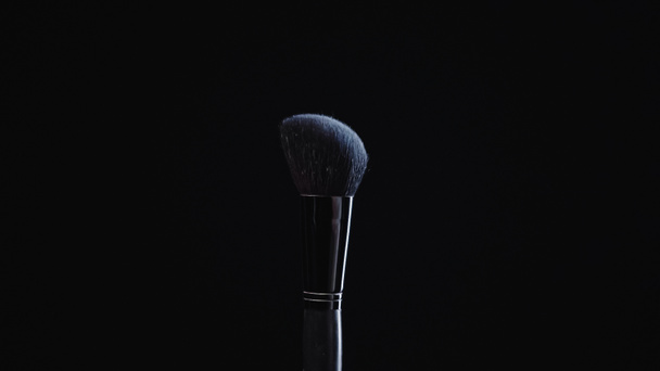 weiche Kosmetikbürste mit blauem Puder isoliert auf schwarz  - Foto, Bild