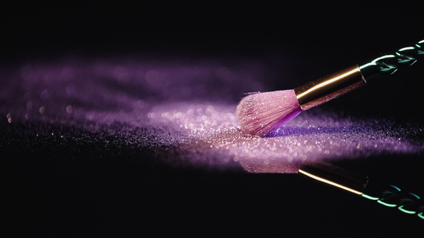soft cosmetic brush near dust with sparkling pink glitter on black  - Φωτογραφία, εικόνα