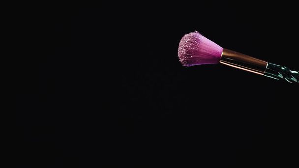 cepillo cosmético suave con polvo rosa brillante aislado en negro  - Foto, Imagen