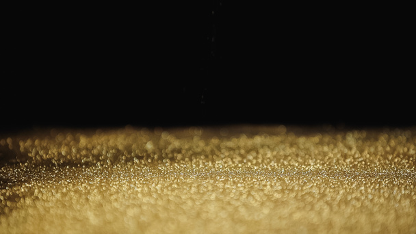 sparkling golden dust with shimmer on black background  - Photo, Image