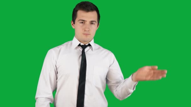 un uomo in giacca e cravatta sporge la mano su uno schermo verde - Filmati, video