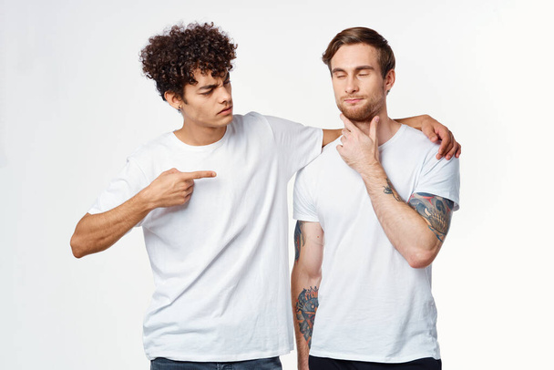 Kaksi iloista ystävää valkoisissa t-paidoissa syleilevät tunteita - Valokuva, kuva