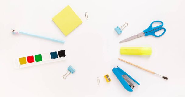 Top view of modern white blue office desktop with school supplies and stationery on table around round empty space for text. Back to school concept flat lay with mockup - Photo, Image