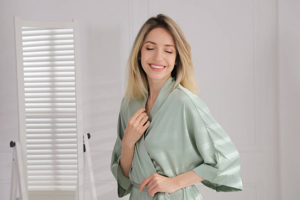 Pretty young woman in beautiful silk robe at home - Фото, зображення