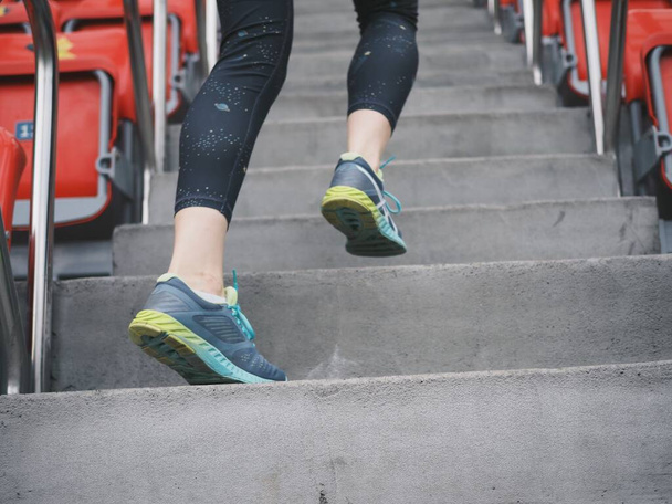mujer joven entra a los deportes, corre en el estadio, se extiende, bebe agua - Foto, Imagen