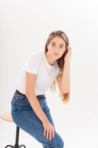 young caucasian pretty girl with long hair in t-shirt, blue jeans at studio - Fotoğraf, Görsel