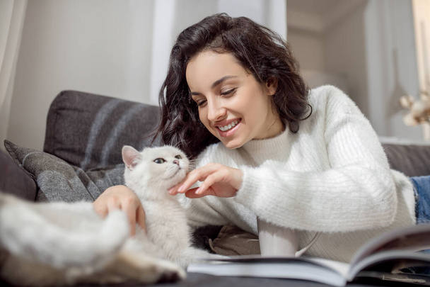 Female pet owner looking happy while spending time with her cat - Foto, Imagem
