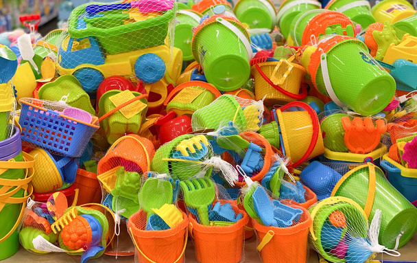 Childrens plastic toys. New toy bucket, blade, rake, cars in the store. Sale of childrens products - Photo, Image