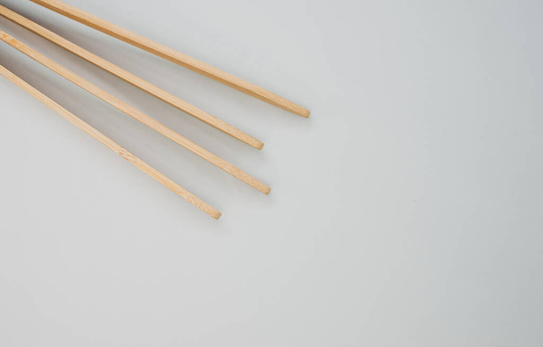 A closeup of two wooden cooking chopsticks on a grey surface - Foto, Imagem