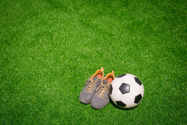 Piłka nożna, piłka nożna i buty sportowe na zielonej trawie - Zdjęcie, obraz
