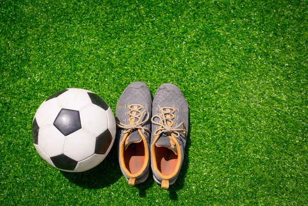 Fútbol, pelota de fútbol y zapatos deportivos en hierba verde - Foto, Imagen
