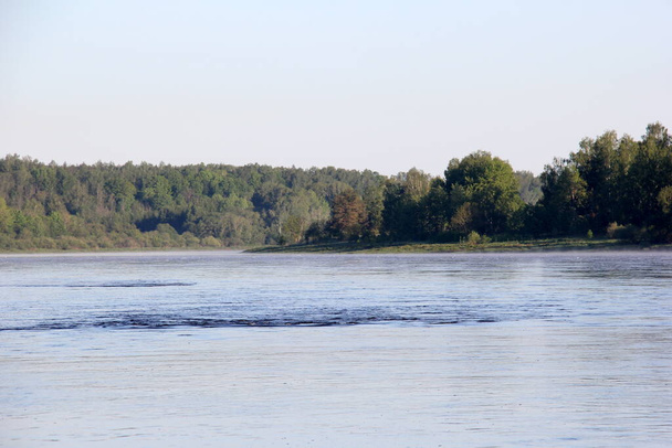 Ένα μεγάλο ποτάμι με λευκό αφρό στην επιφάνεια, κατά τη διάρκεια του καλοκαιριού. Ποταμός Daugava, Λετονία - Φωτογραφία, εικόνα